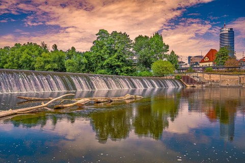 The weir of the river Saale in Paradies Park with the Jentower in the background at sunrise, Jena