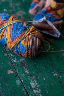 Handwork, knitted sock with knitting needles and wool