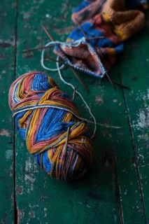 Handwork, knitted sock with knitting needles and wool