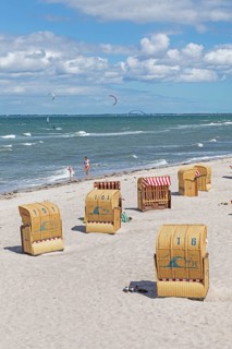 Beach chairs, kite surfers