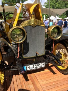 Front view front with radiator grill round lamps spoke wheel of historic racing car from early 20th century 1919 Audi Phaeton Type C Alpine winner, Classic Days
