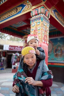 Ladakhi woman carrying her grandson on her shoulders, Leh