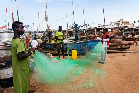 Fishermen mending nets, fishing boats