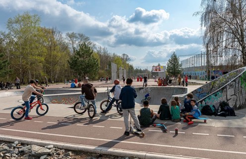 Skateboarders and cyclists at a skate pool in the Park am Gleisdreieck in Berlin-Mitte, Berlin