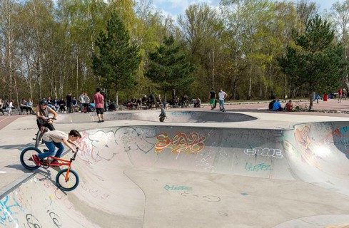 Skateboarders and cyclists at a skate pool in the Park am Gleisdreieck in Berlin-Mitte, Berlin