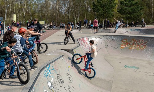 Skateboarders and cyclists at a skate pool in the Park am Gleisdreieck in Berlin-Mitte, Berlin