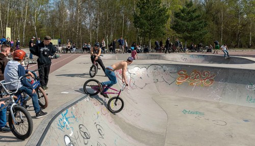 Skateboarders and cyclists at a skate pool in the Park am Gleisdreieck in Berlin-Mitte, Berlin