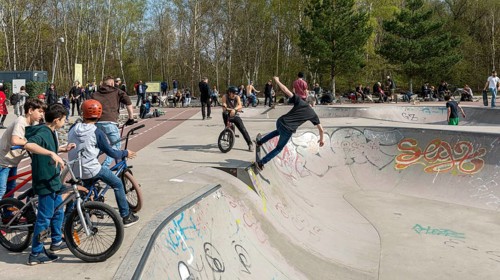 Skateboarders and cyclists at a skate pool in the Park am Gleisdreieck in Berlin-Mitte, Berlin