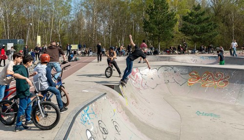 Skateboarders and cyclists at a skate pool in the Park am Gleisdreieck in Berlin-Mitte, Berlin