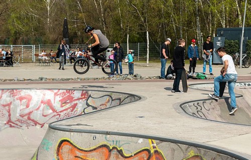 Skateboarders and cyclists at a skate pool in the Park am Gleisdreieck in Berlin-Mitte, Berlin