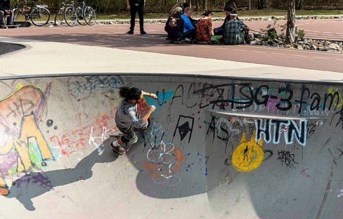 Skateboarders and cyclists at a skate pool in the Park am Gleisdreieck in Berlin-Mitte, Berlin