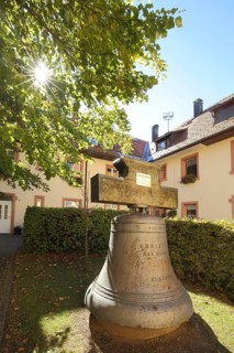 Bell in the courtyard of the monastery church of the Assumption of the Virgin Mary in the backlight in St. Maergen, Southern Black Forest
