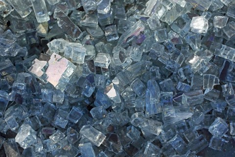 Broken glass pane and a pile of small glass shards and glass splinters,
