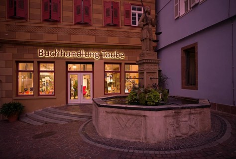 Justitia fountain, behind it bookshop Taube