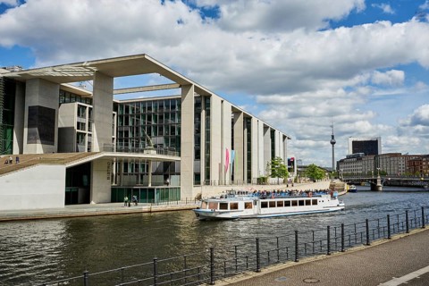 Marie-Elisabeth-Lueders-Haus designed by architect Stephan Braunfels, in front the Spree with a pleasure boat