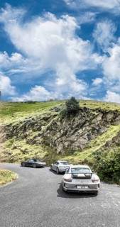Three Porsche sports cars in front 911 GT3 behind Cayman 718 in the background 911 997 driving through a bend at Passo della Teglia, Ligurian Alps