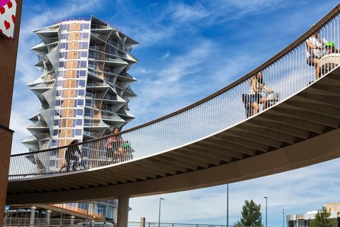 Cyclists on bridge at Kaktus Tower skyscraper, Cykelslangen bicycle bridge