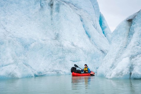 Man with packraft at sea