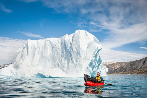 Man with packraft on fjord