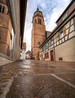 Tunnel view of the church through an alley of half-timbered houses