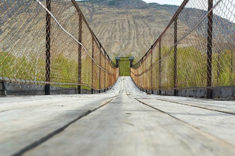 Suspension bridge over a mountain river in a gorge. Russia