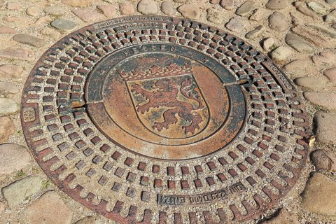Manhole cover with the coat of arms of Seligenstadt. Seligenstadt