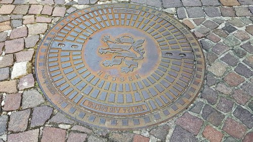 Manhole cover with the coat of arms of Seligenstadt. Seligenstadt