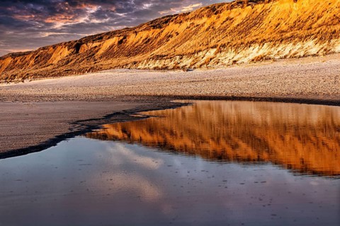 Red cliff reflected in the water