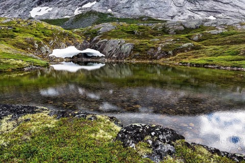 Remnants of snow and rocks reflected in the water
