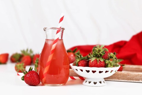 Red strawberry fruit lemonade in jar with raw berries