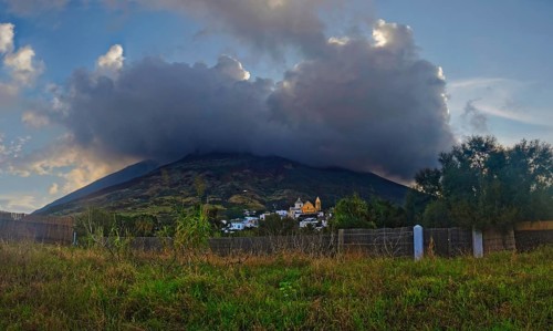 Small fishing village and harbour of San Vincenzo in front of the volcanic cone of Stromboli at sunset