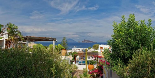Town of Panarea with view of the small island Le Guglie of a former volcano and the volcanic island Stromboli