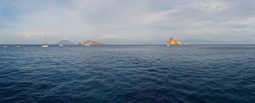 Le Guglie Island and di Basiluzzo of a former volcano and the volcanic island of Stromboli with anchored sailing ships