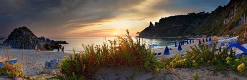 Panorama on the sandy beach and bay Capo Vaticano at sunset