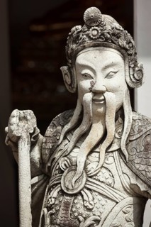 Chinese stone guardian statue close up in Wat Pho Buddhist Temple