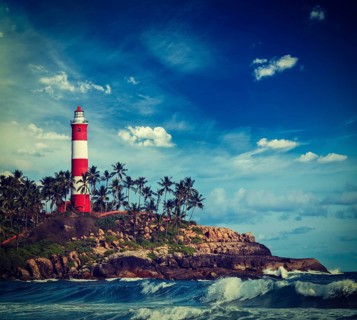 Vintage retro hipster style travel image of old lighthouse and waves of sea. Kovalam