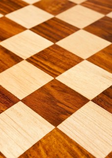 Wooden chess board with brown and yellow squares background