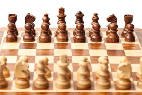 Wooden chess pieces on chessboard. Selective focus