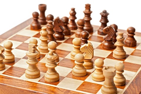 Wooden chess pieces on chessboard. Selective focus