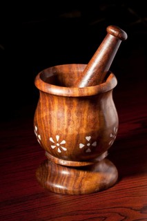 Wooden mortar and pestle on dark wood background