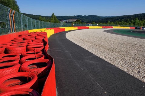 Safety measure for car racing Impact protection red yellow coloured tyre piles next to gravel bed in turn 8 of racetrack for motorsport
