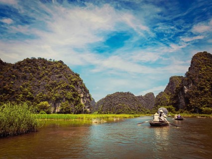 Vintage retro effect filtered hipster style image of tourists on boats in Tam Coc-Bich Dong Ngo Dong river in popular tourist destination near Ninh Binh