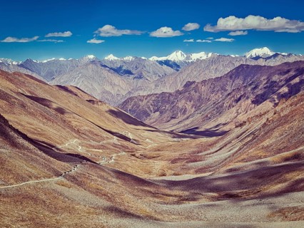 Vintage retro effect filtered hipster style image of Karakoram range and road in valley from Kardung La