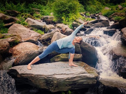Vintage retro effect hipster style image of fit woman practices yoga asana Utthita Parsvakonasana