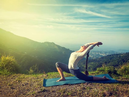 Vintage retro effect hipster style image of sporty fit woman practices yoga Anjaneyasana