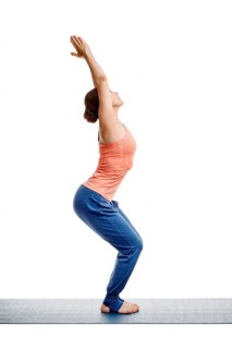 Sporty fit woman doing Surya Namaskar ashtanga vinyasa yoga asana Utkatasana
