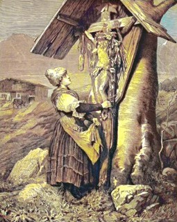 Woman in front of a field cross in the Alps