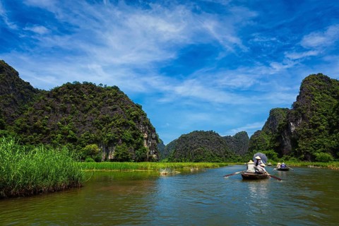 Tourists on boats in Tam Coc-Bich Dong Ngo Dong river in popular tourist destination near Ninh Binh