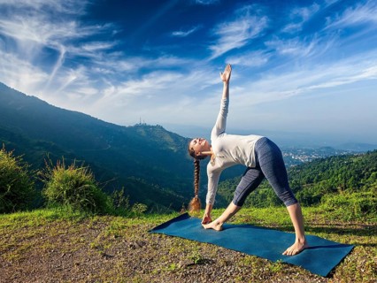 Woman doing Ashtanga Vinyasa yoga asana Utthita trikonasana