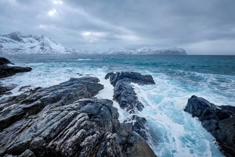 Waves of Norwegian sea crushing at rocky coast in fjord. Vikten